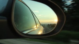 stock-footage-early-morning-drive-on-a-country-road-with-view-of-sunrise-from-side-mirror-of-the-car